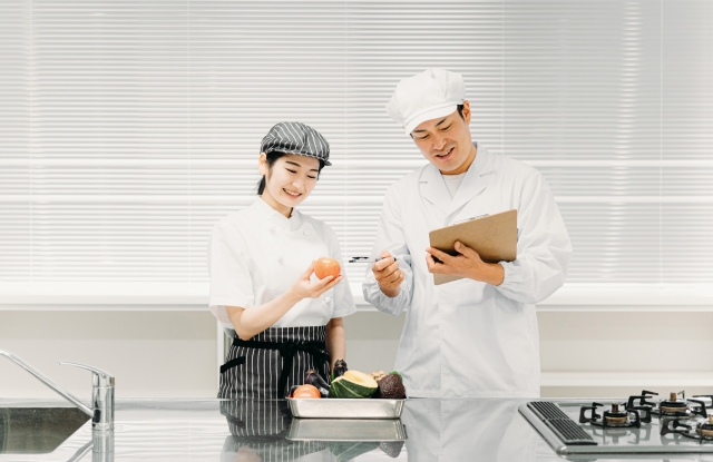厨房で食材と手順を確認する料理人