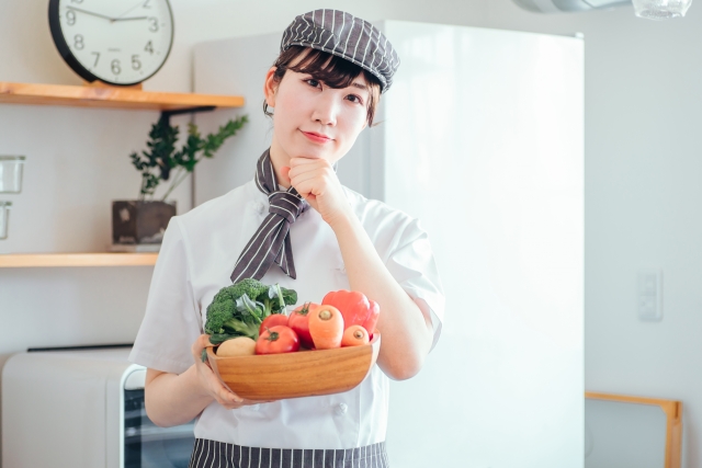 野菜を持ち経営改善を考える飲食店スタッフ