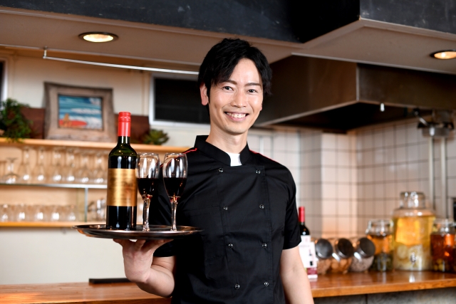 ワインを提供する飲食店スタッフ
