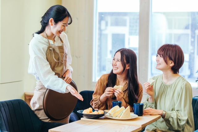 来店客に料理を案内する飲食店スタッフ