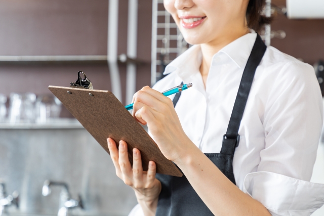 チェック項目を記録する飲食店スタッフ